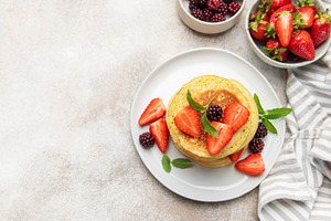 Stacking berry pancakes for a delicious breakfast meal, a Food & Drink Photo by Olena Rudo