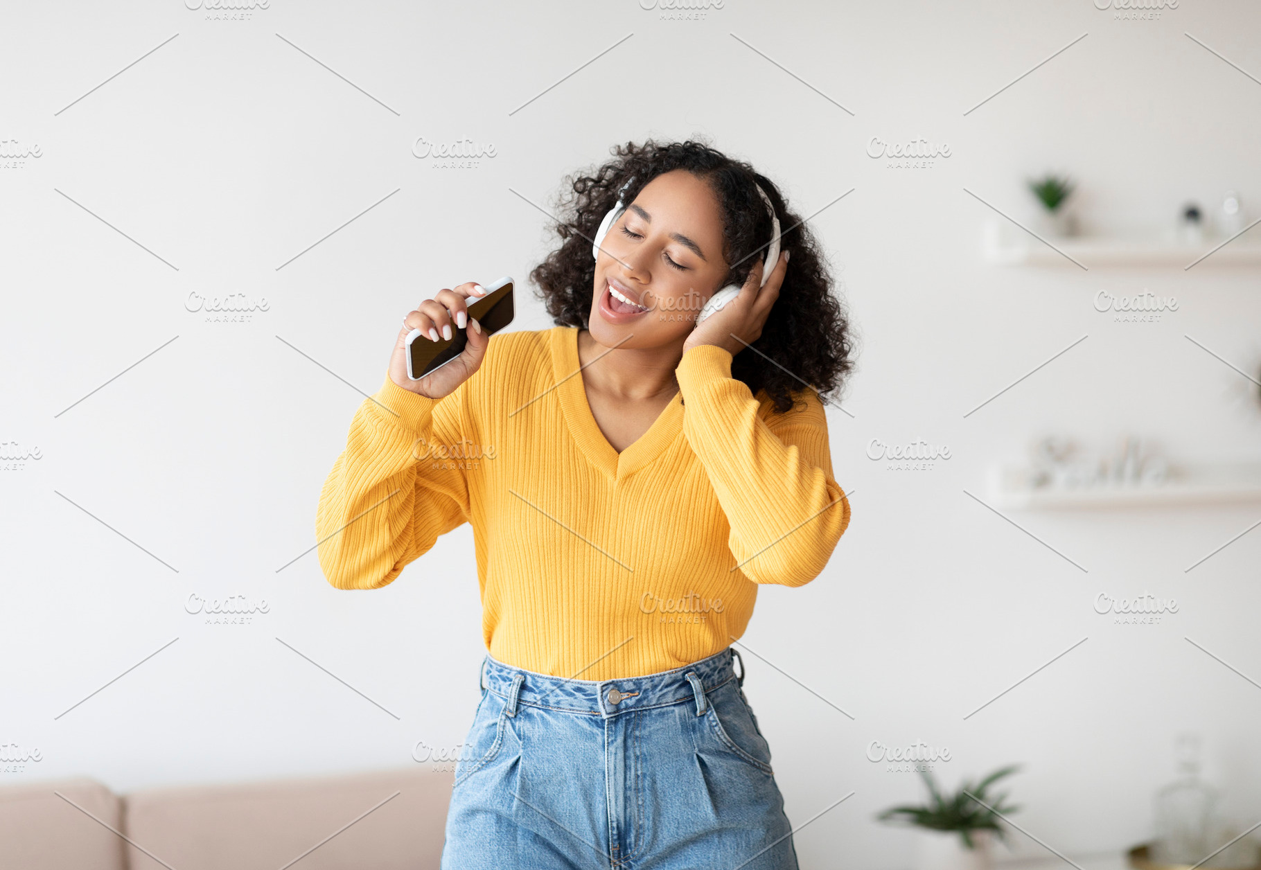 Cool karaoke or music app. Beautiful black woman in wireless headphones using s, a Photo by Prostock-Studio
