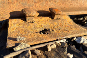 Close-up of rusty railroad track components on gravel, an Industrial Photo by Textures & Backgrounds