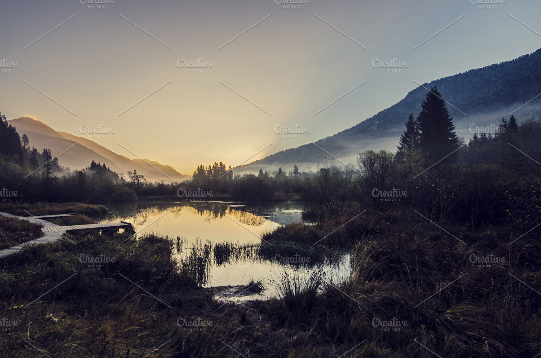 Sunrise at lake with mountains featuring murky, mystic, and forest, a Nature Photo by PremiumCoding