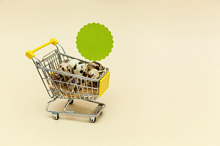 Metal shopping cart on a beige background., a Food & Drink Photo by Photostock