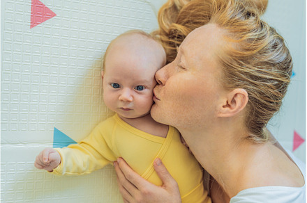 Mother and baby lying on a play mat