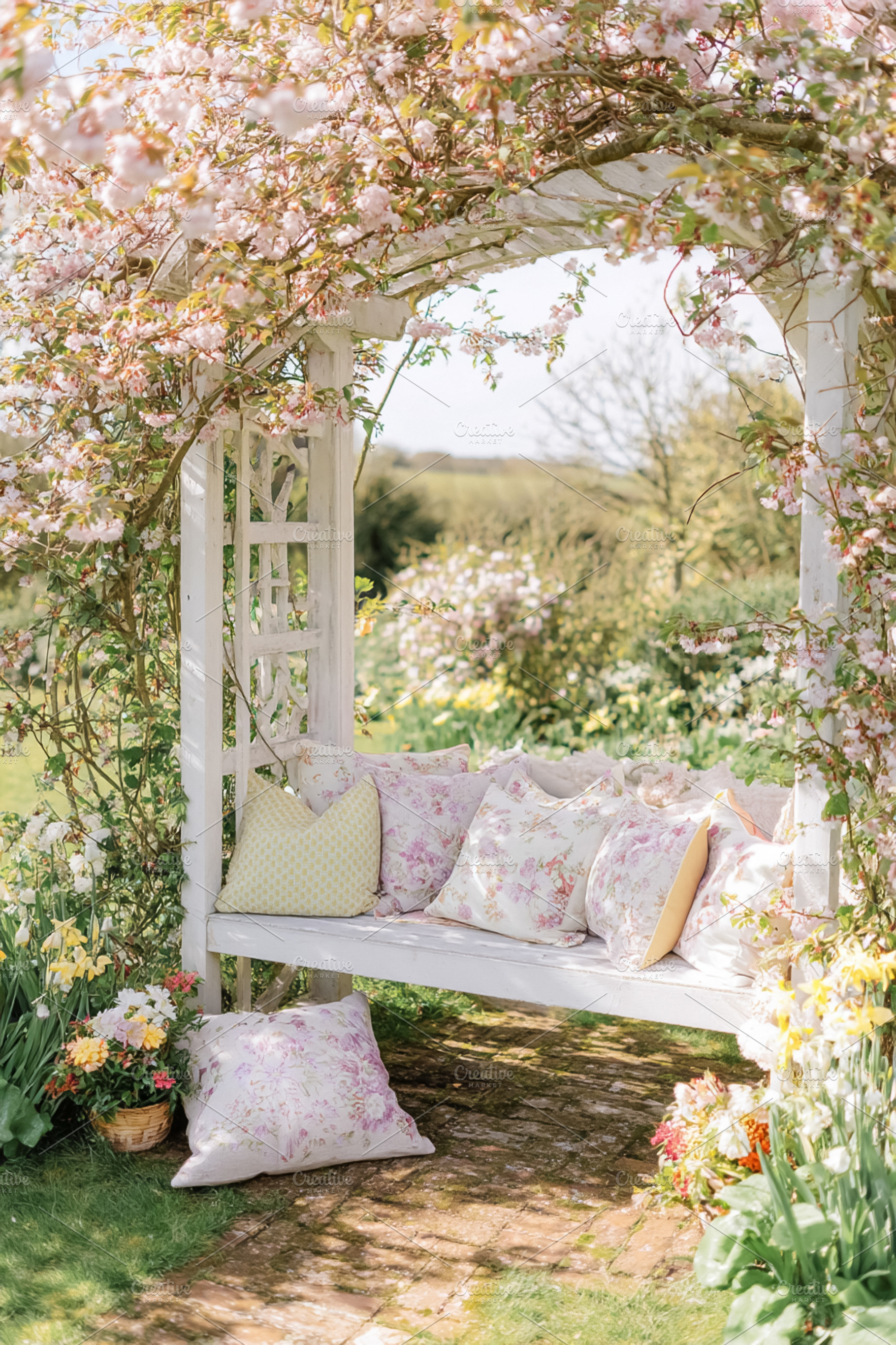Pergola covered with cherry blossom and white garden bench with, a Photo by Studio ANNA