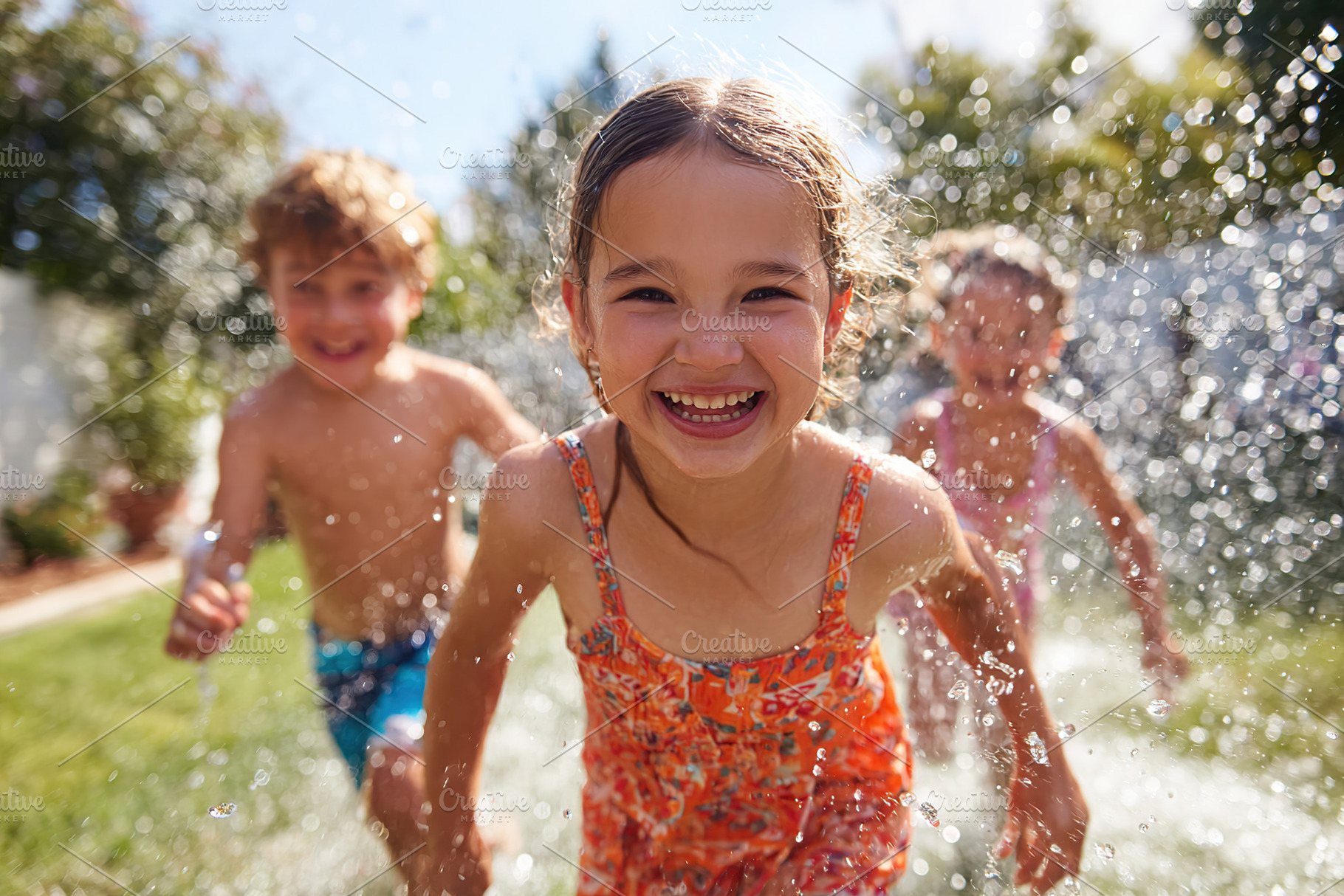 Children joyfully running through sprinklers on a sunny day in the backyard, a Person Photo by AlyaAnd