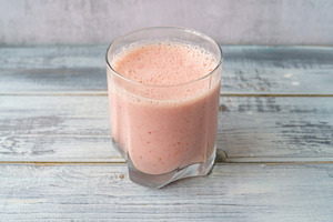 Fresh pink smoothie in clear glass on light gray wood background. Healthy refre, a Food & Drink Photo by Eugene_Photo