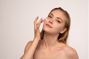 Young woman applying face cream, a Beauty & Fashion Photo by volodymyrshtun13795