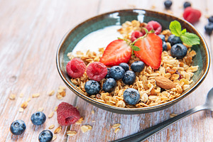 Granola bowl with fresh berries for a healthy breakfast, a Food & Drink Photo by Olena Rudo