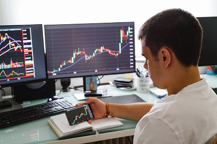 Successful young trader in casual wear working with charts and market reports a, a Person Photo by Architect´s eye