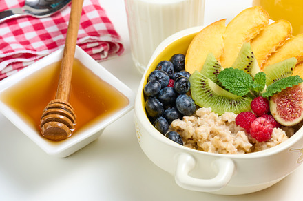 plate with oatmeal and fruit, honey in a bowl on a white table, a Food & Drink Photo by ndanko