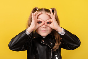 Young girl in a black leather jacket making pretend glasses with, a Person Photo by Ales Munt