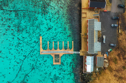 Aerial view of wooden pier, azure water, houses on the sea coast, a Nature Photo by den-belitsky