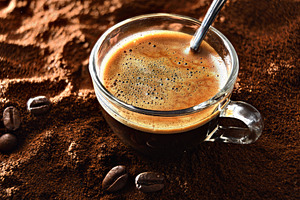 Glass coffee cup over ground coffee and beans around it, a Food & Drink Photo by Davizro's Market