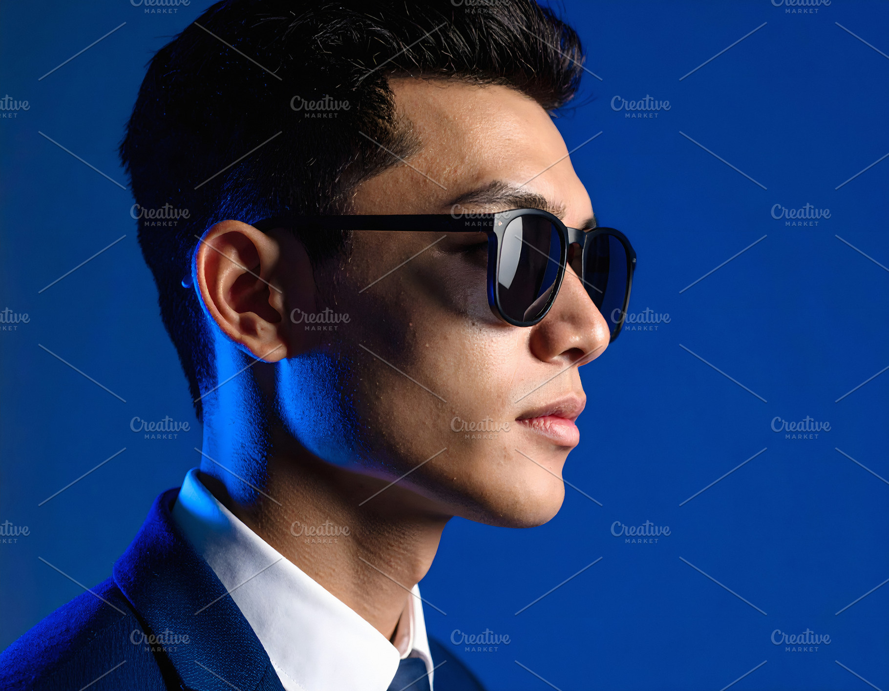 Businessman in elegant suit wearing sunglasses with blue light, a Business Photo by GoodGoods