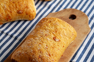 Homemade Cheese Ciabatta Bread on a Wooden Board, side view.