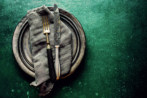 Vintage cutlery on plate on green ta