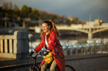 happy stylish woman outdoors on city street riding bicycle, a Person Photo by Alliance Images