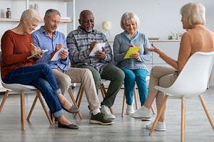 Multiracial group of elderly men and women having educational class, a Photo by Prostock-Studio