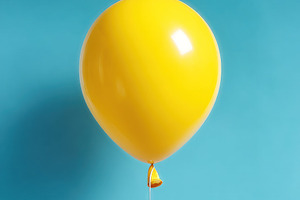 Bright yellow balloon floating on blue background with string, c, a Holiday Photo by José Manuel Gelpi