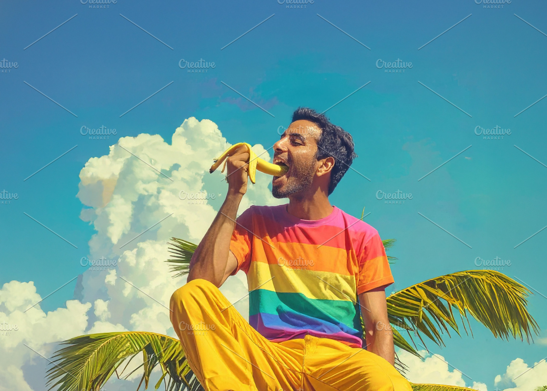 A young man eating a banana at the top of a palm tree, a Person Photo by DanFLCreativo