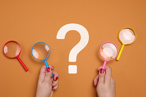 Female hands holding a plastic magnifying glass and a question m, a Business Photo by ndanko