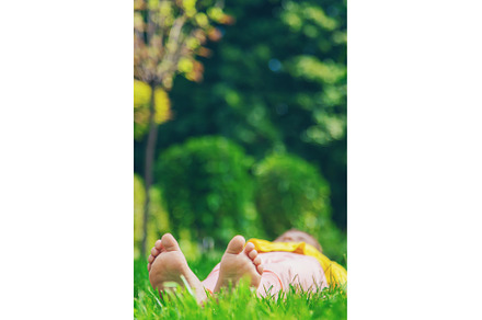 The child lies on the grass, a Person Photo by yanadjana