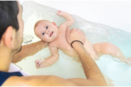 The father bathes the little baby, a Person Photo by yanadjana