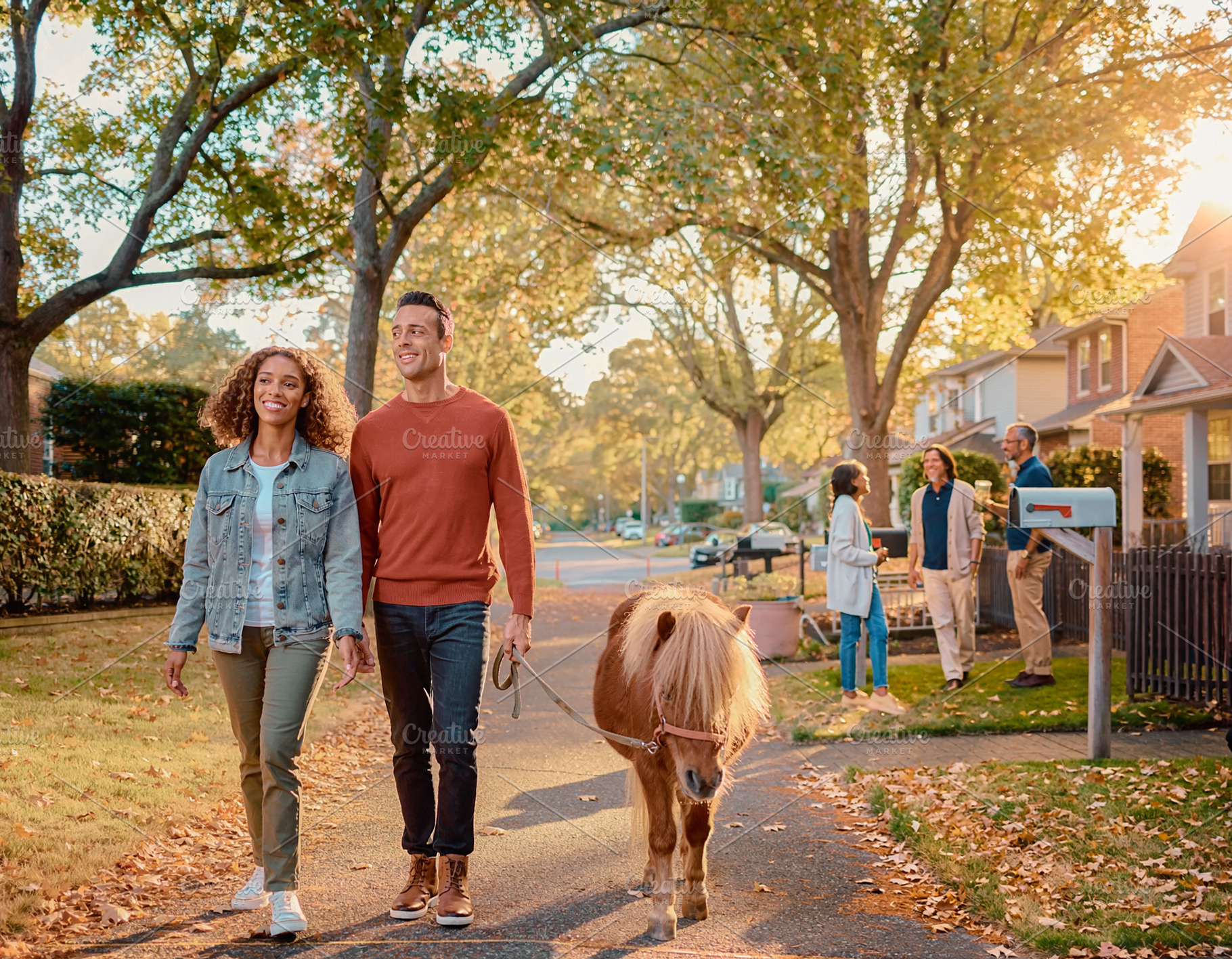 Adult couple walking pony outdoors in autumn neighborhood, a Person Photo by DanFLCreativo