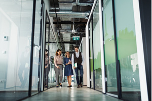 Group of coworkers walking down the, a Business Photo by HalfPoint