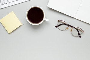 Cozy workspace with coffee, keyboard, glasses, and notebook setting a focused m, a Photo by matucha