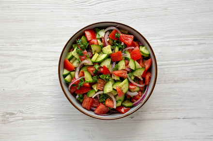 Homemade Mediterranean Cucumber Tomato Salad in a Bowl, top view, a Food & Drink Photo by LiudmylaChuhunova