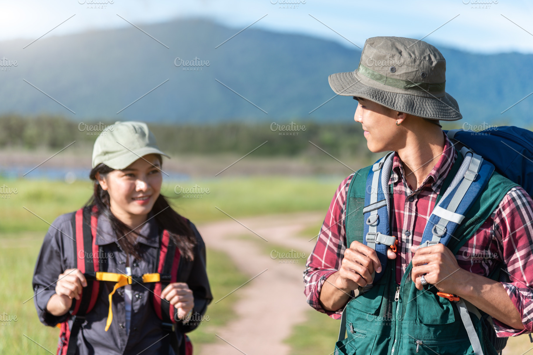 Two people walking on path in meadow field. Male and female trav, a Person Photo by Ministocker