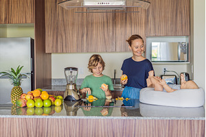 Mother and son preparing smoothie in