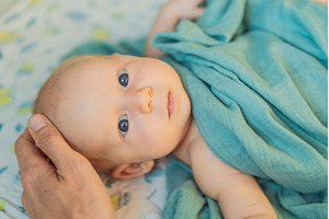 Father gently stroking his newborn, a Person Photo by Elizaveta Galitskaya