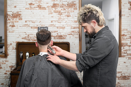 Man barber cutting hair of male client with clipper at barber shop. Hairstyling, a Person Photo by david.herraez.calzad