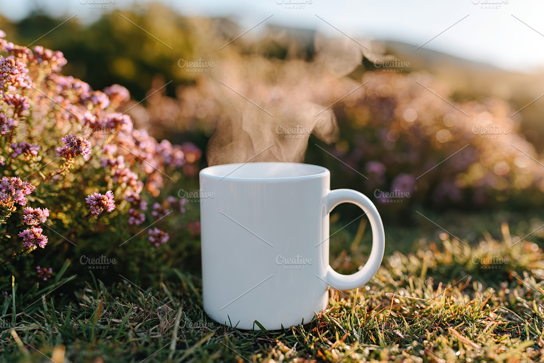 Steam rises from a mug placed on lush grass surrounded by vibrant flowers in so, a Food & Drink Photo by AlyaAnd