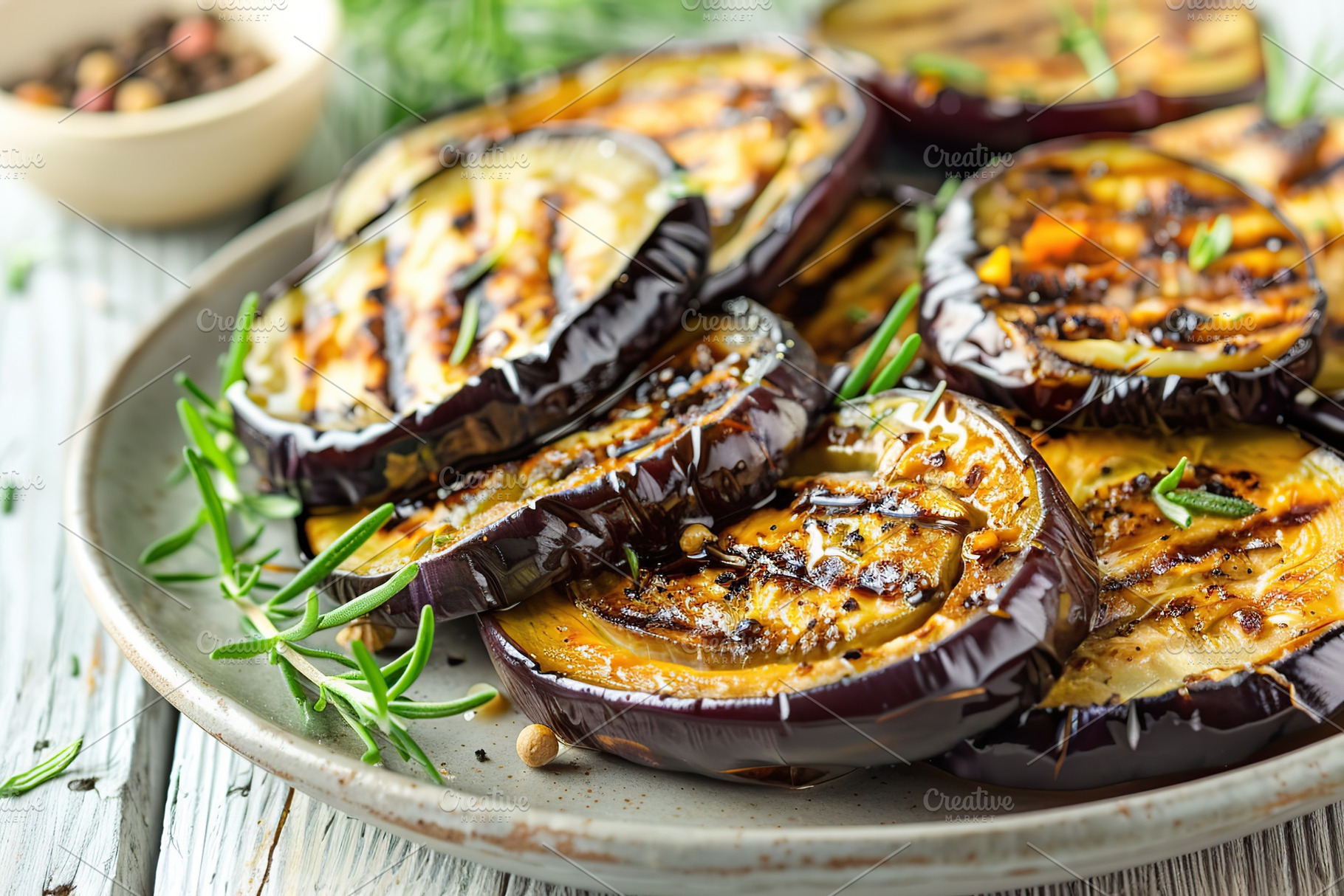 Slices of grilled eggplants in plate on wooden table, a Food & Drink Photo by AlyaAnd