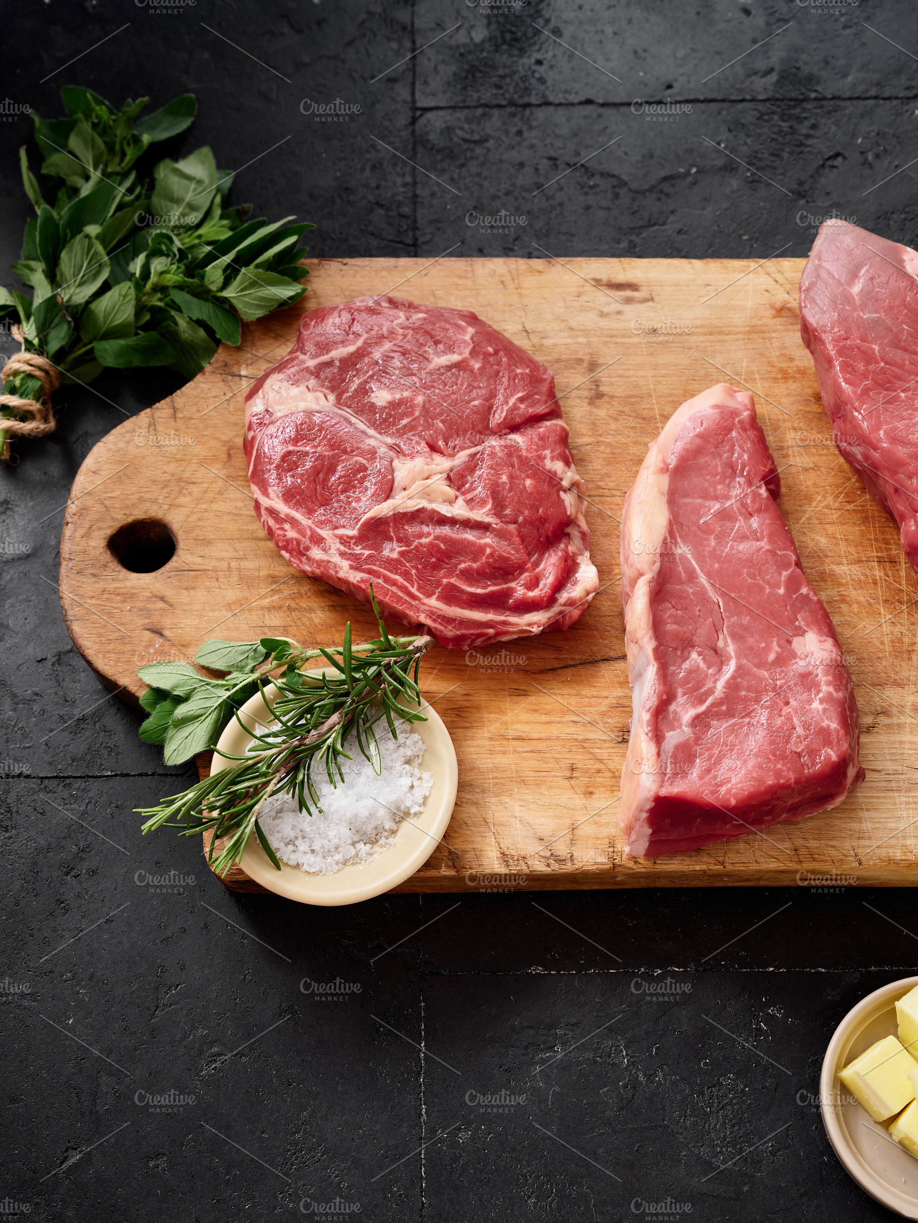 Raw rib-eye, roast beef, flank, and rump steak placed on a wooden cutting board, a Food & Drink Photo by Asya Nurullina