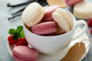 Vanilla and raspberry macarons in a teacup