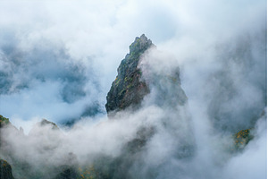 A mountain covered in fog and clouds, a Nature Photo by f9photos
