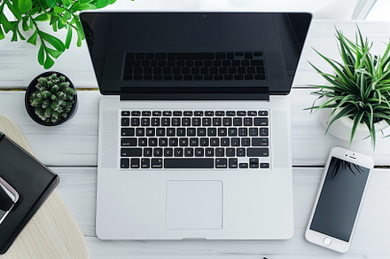 A sleek laptop sits open beside a sm, a Photo by Tanuart