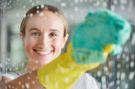 Cleaning, washing and portrait of woman by window with foam, cleaning products and cloth for housework. Spring cleaning, housekeeping and happy girl wipe dirt and dust on glass window for clean home, a Photo by Peopleimages.com