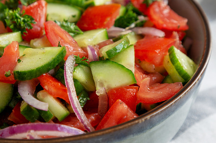 Homemade Mediterranean Cucumber Tomato Salad in a Bowl, side vie, a Food & Drink Photo by LiudmylaChuhunova