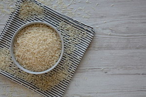 Uncooked White Organic Basmati Rice in a Bowl, top view. Space f, a Food & Drink Photo by LiudmylaChuhunova