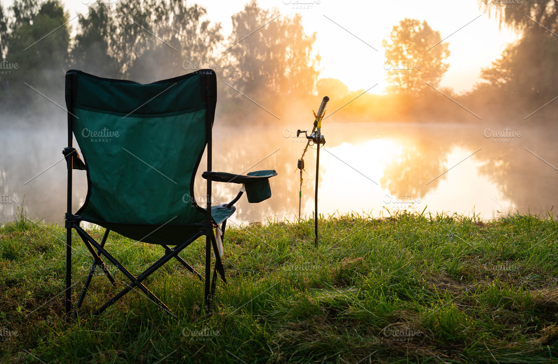 Fisherman's chair and fishing rods in the background over the lake at sunrise,, a Nature Photo by Artsaba Family