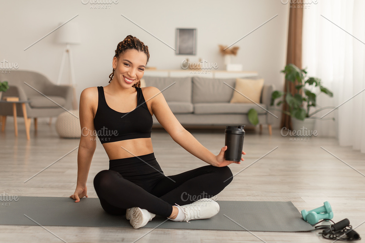 Black Fitness Lady Holding Cup Drinking Water During Workout Indoor, a Photo by Prostock-Studio (Photo 1 of 2)