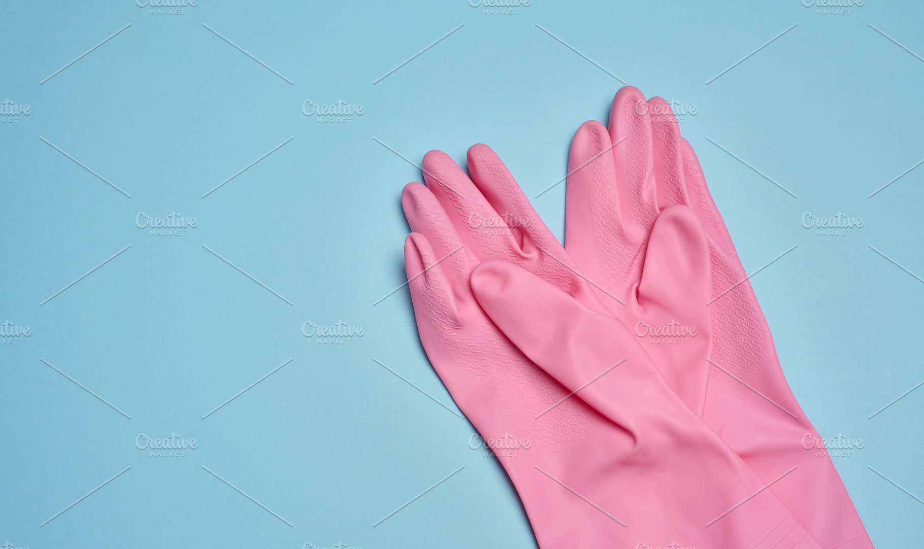 A pair of pink rubber gloves on a blue background, a Background Photo by ndanko