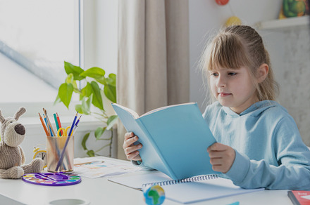Cute little girl sitting at desk in bedroom, doing homework, studying at home, a School & Education Photo by Lenor4ik