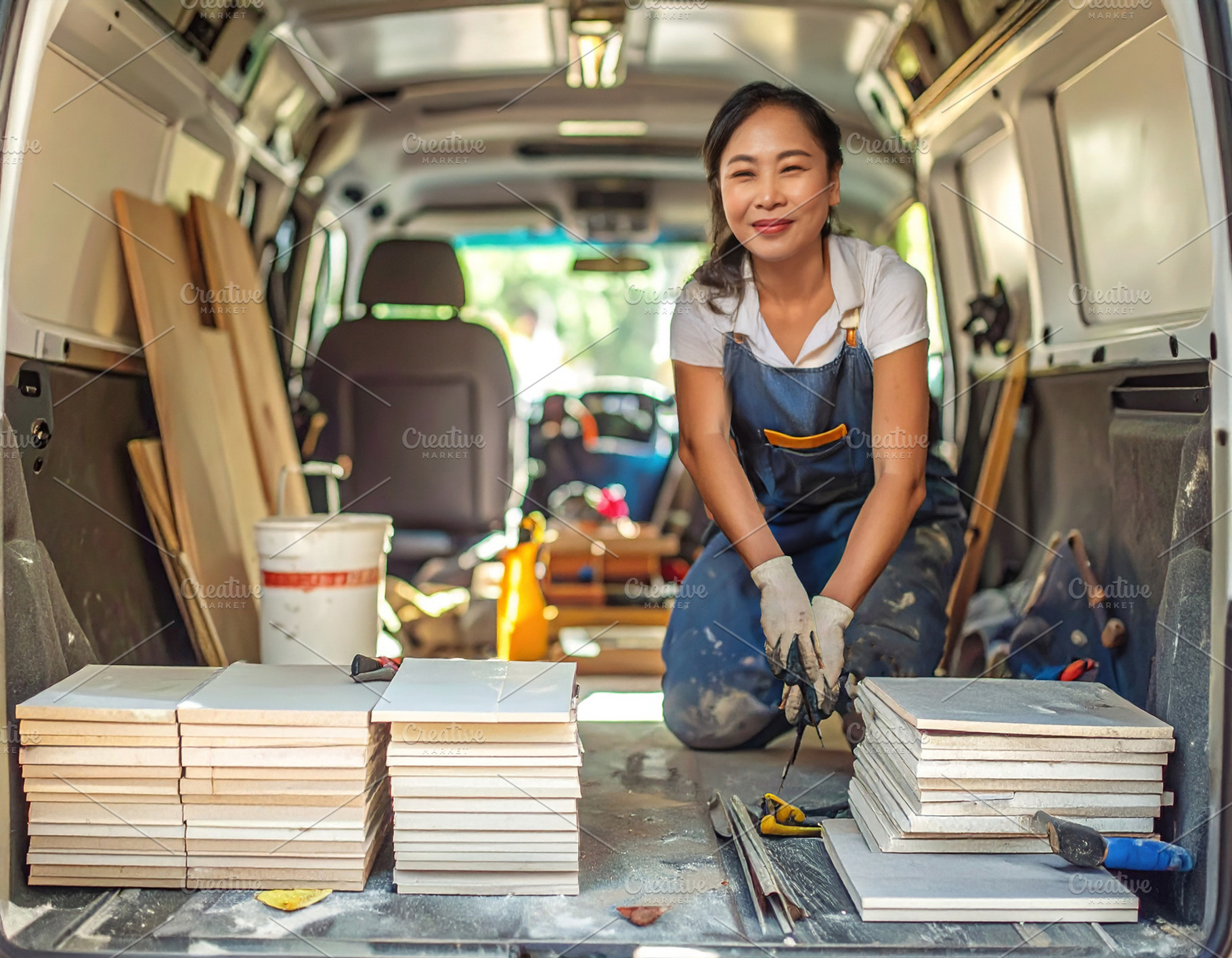 Tile mason organizing materials and tools in the van, a Person Photo by DanFLCreativo