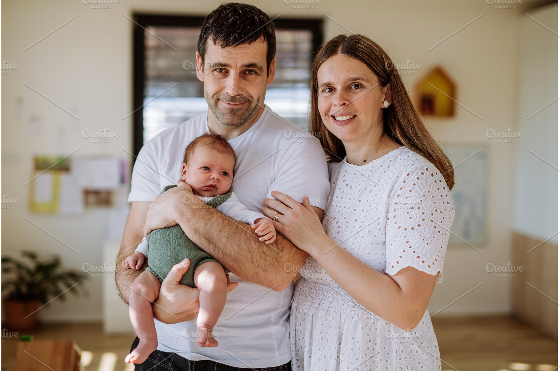 Happy parents cuddling with their, a Person Photo by HalfPoint