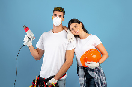 Young couple ready for repair, posing with construction tools over blue backgro, a Background Photo by Prostock-Studio
